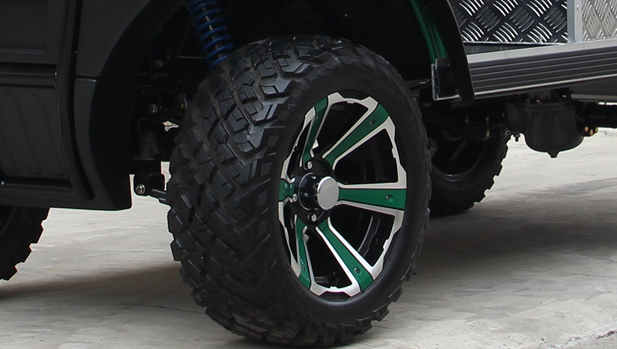 Close-up of Tara utility task vehicle tire with deep off-road tread pattern, designed for superior traction on dirt and grass